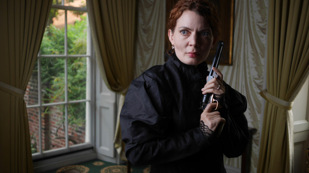 Jennifer Summerfield as Hedda Gabler holding one of General Gabler's pistols. Designer Paul Kuhn created the case for these guns. Photo by Kyle Cassidy.