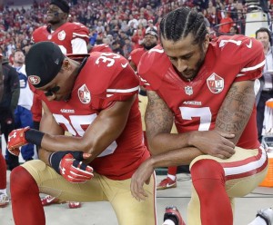 Colin Kaepernick right) and teammate kneeling during the national anthem.